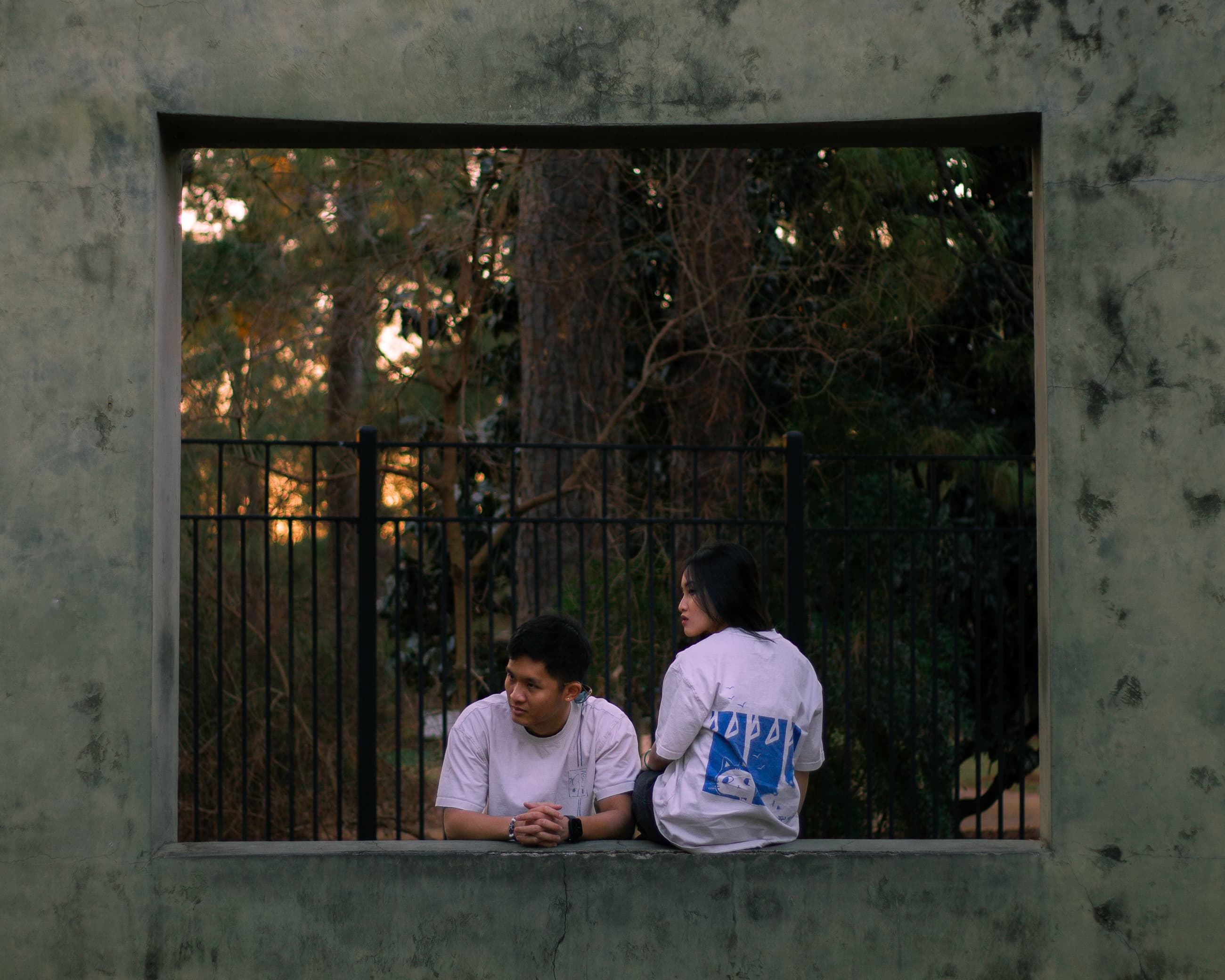 two people sitting on a window platform